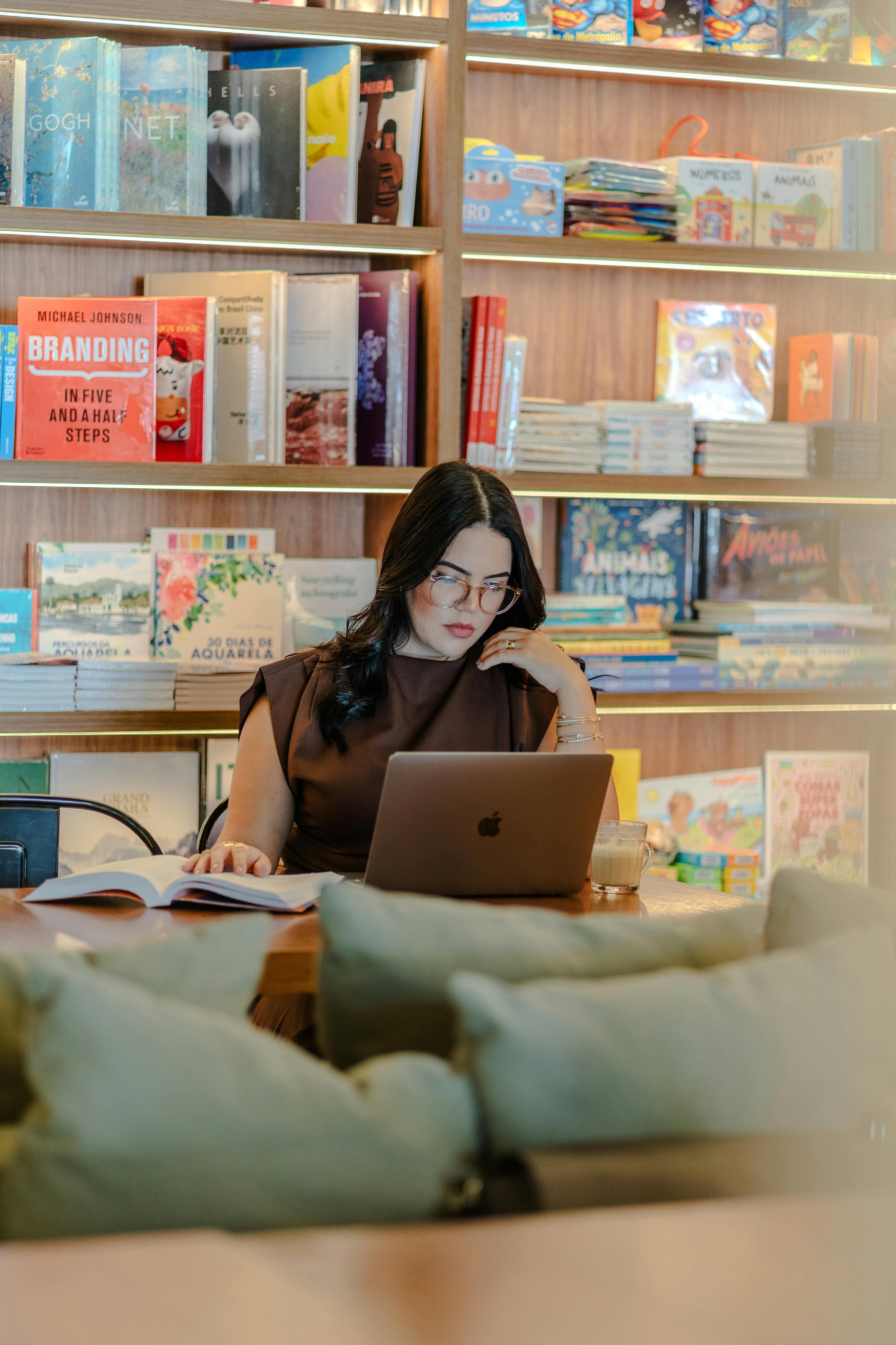 Aufgeschlagene Bücher neben einem Laptop auf einem Schreibtisch